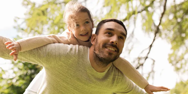 Padre con su hija sobre su espalda