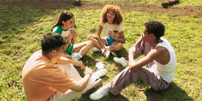 Varios adolescentes reunidos jugando a las cartas